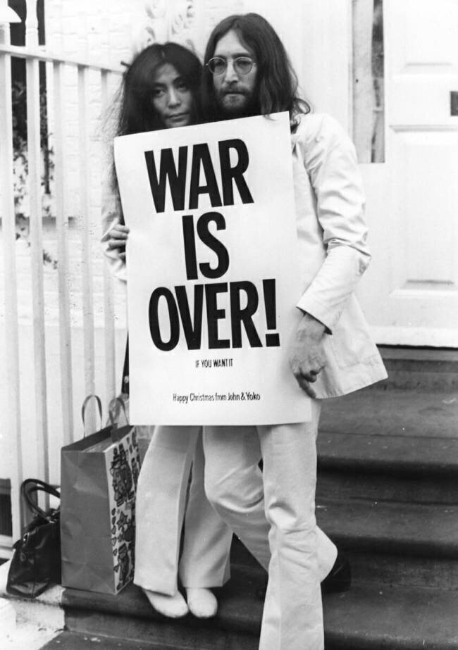 John Lennon and his wife Yoko Ono pictured with one of their war protest poster anonyme