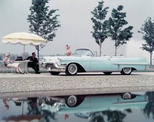 Profil latéral d'une femme adulte de taille moyenne se tenant à côté d'une Cadillac décapotable (anonyme) - Muzeo.com